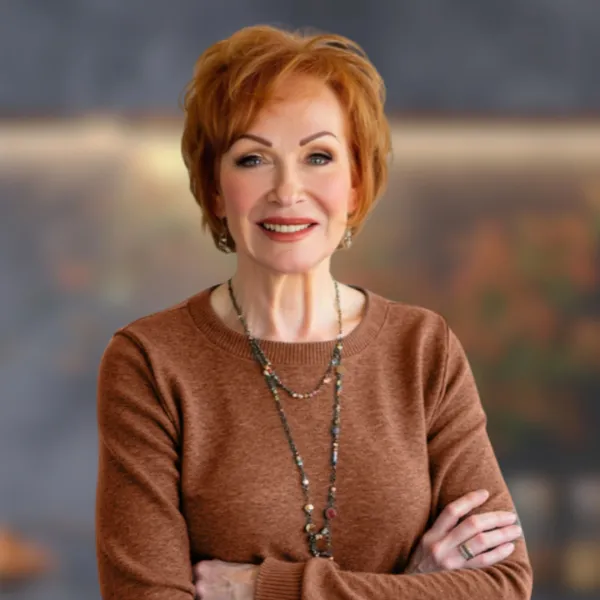 Ann Louise Gittleman, creator of the Fat Flush Soup Diet, smiling with arms crossed in a rust-colored sweater